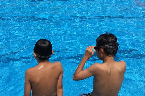 2 boys sitting at a pool at a Euroresorts campsite